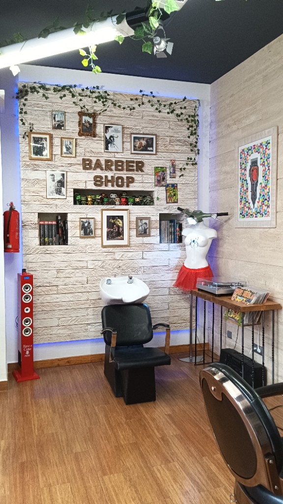 Zona de lavado con pared decorada y sillón de barbería en Hidalgo Junior.